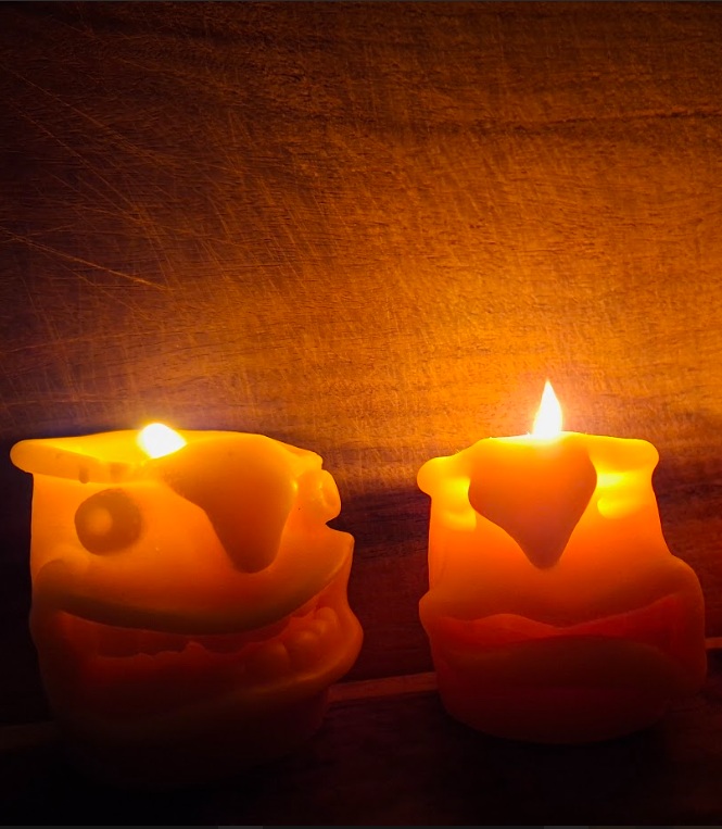 שני נרות LumiNer דולקים עם מרקם שעווה חם על רקע עץ